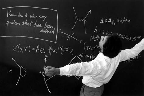 Scientist writing formulas and diagrams on a blackboard