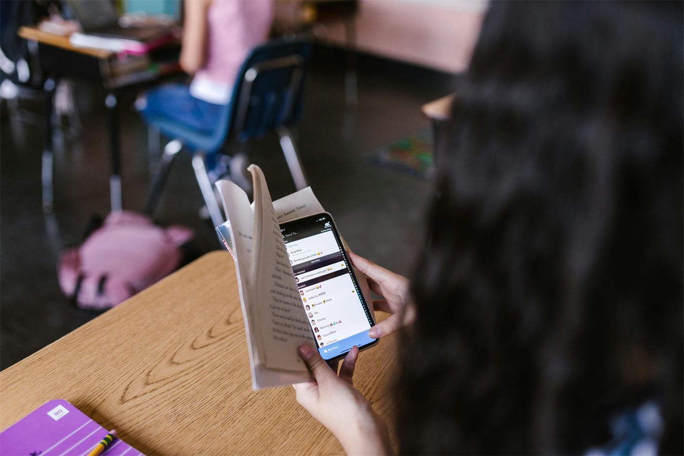 Student distracted by a phone while studying